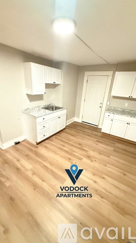 A kitchen with wooden floors and white appliances is available for rent.