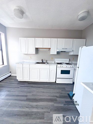A kitchen with white appliances and cabinets.
