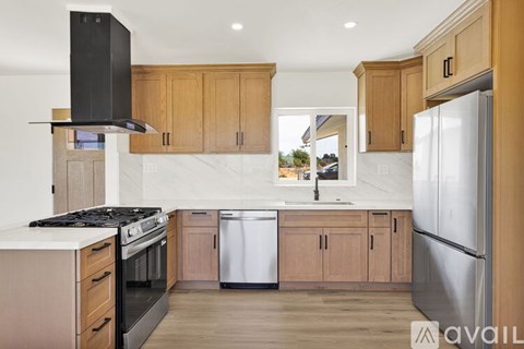 A kitchen with wooden cabinets and a black range hood.