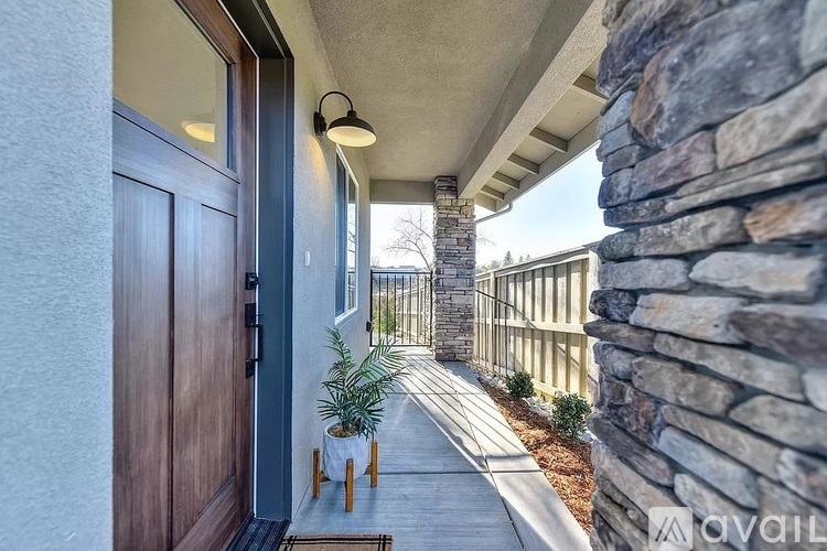 A house entrance with a wooden door and a stone wall.