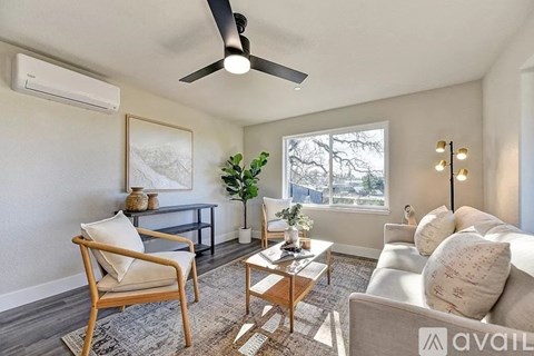 A living room with a ceiling fan, a chair, a couch, and a coffee table.