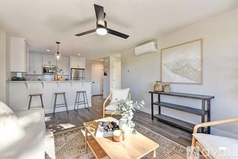 A living room with a white couch, a wooden coffee table, and a painting on the wall.