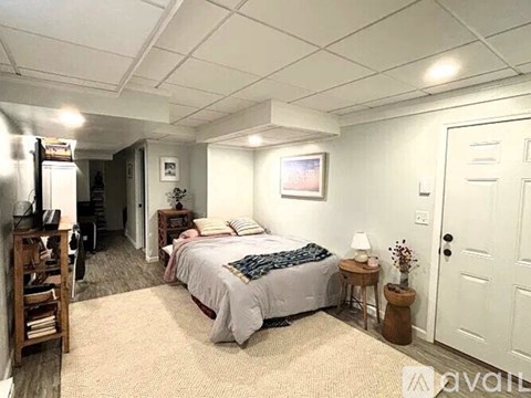 A bedroom with a bed, nightstand, and a chair.