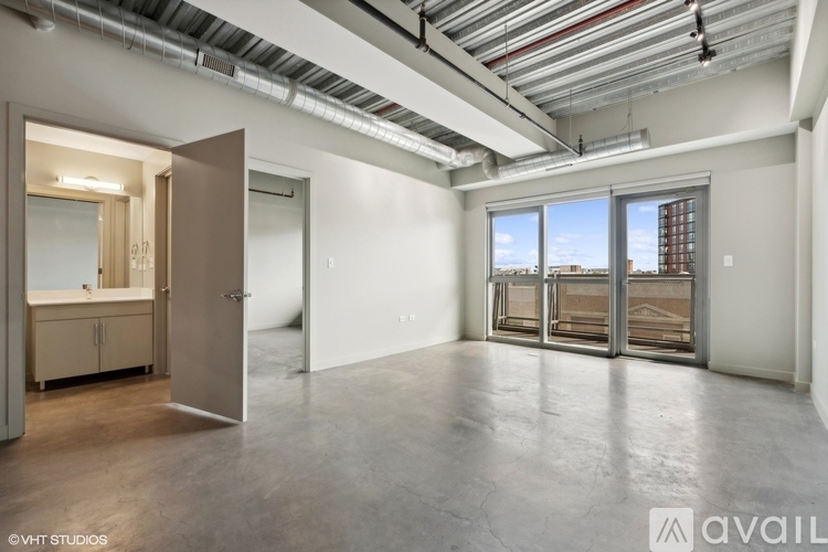 A spacious empty room with a view of a building outside the window.