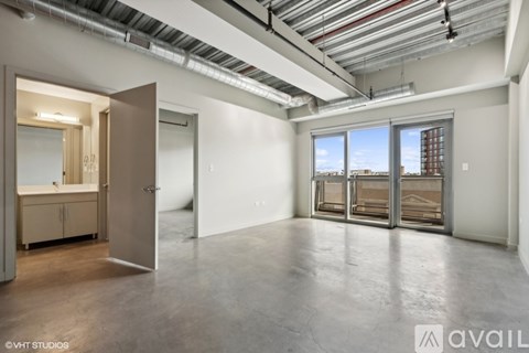 A spacious empty room with a view of a building outside the window.
