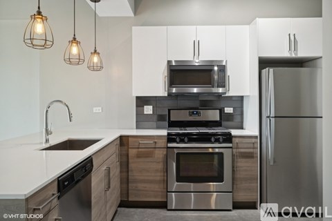 A modern kitchen with a stainless steel refrigerator, microwave, and oven.
