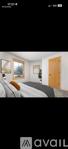 A bedroom with a bed, a window, and a door.