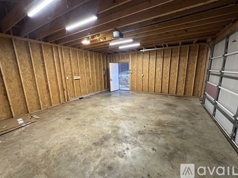 A spacious unfinished room with a doorway leading to another room.