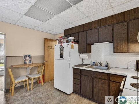 A kitchen with white appliances and wooden cabinets.