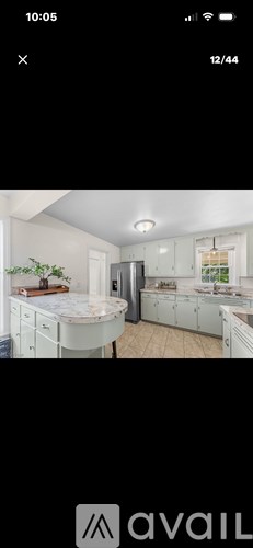 A kitchen with white cabinets and a refrigerator.