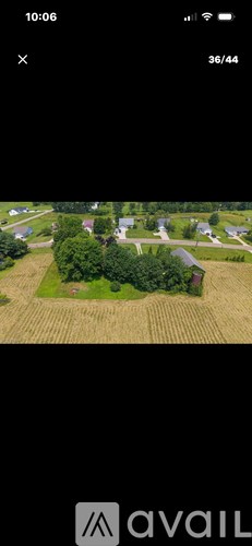 A drone image of a rural area with a house and trees.