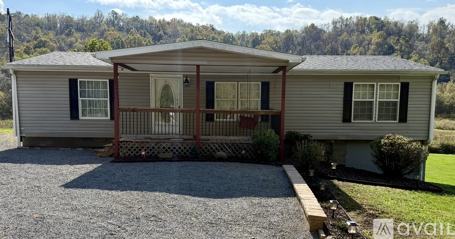 A house with a gravel driveway and a wooden fence.