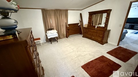 A bedroom with a large bed and a dresser.