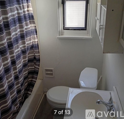 A small bathroom with a toilet and a shower curtain.