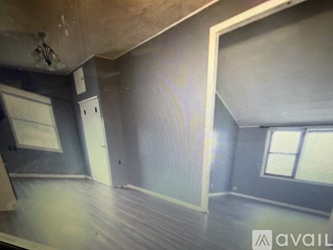 A room with a window and a door is available for rent.