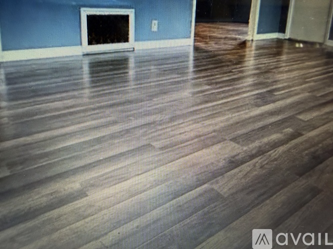 A room with a wooden floor and a fireplace.