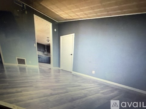 A room with a wooden floor and a white door.