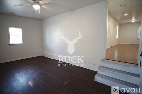 A room with a deer head on the wall and a ceiling fan.