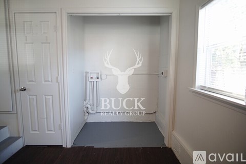 A room with a deer head wall decoration and a logo for Buck Realty Group.