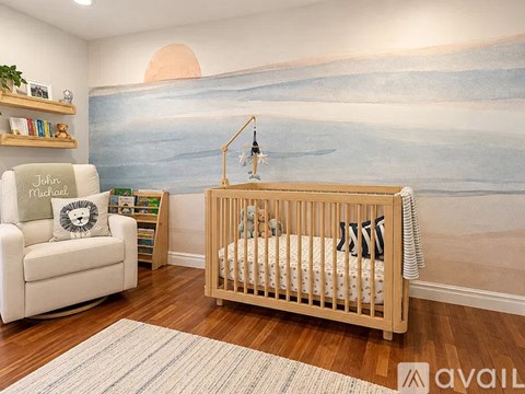 A baby's room with a mural of a beach scene on the wall.