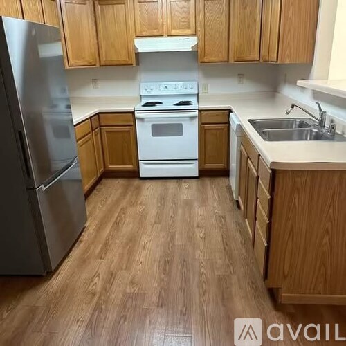 A kitchen with wooden cabinets and a white stove top oven.