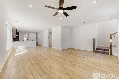A spacious room with a ceiling fan and wooden flooring.
