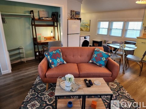 A living room with a couch, a coffee table, and a rug.