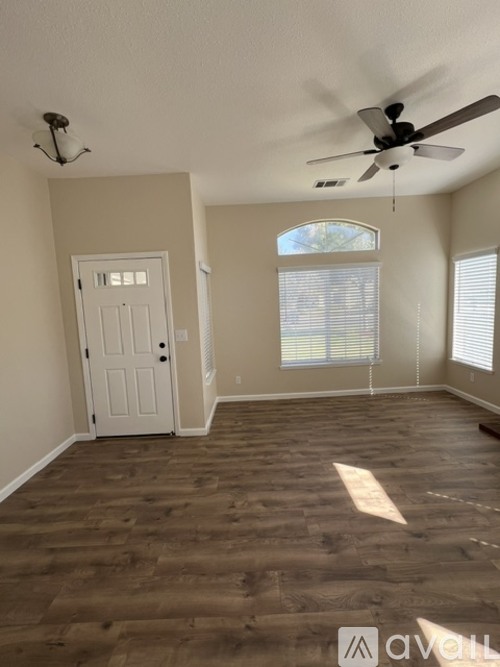 A room with a ceiling fan and a door.