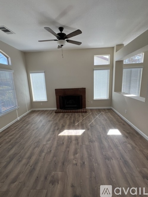 A room with a fireplace and a ceiling fan.