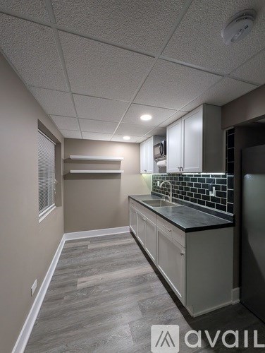 A kitchen with a black counter top and white cabinets.