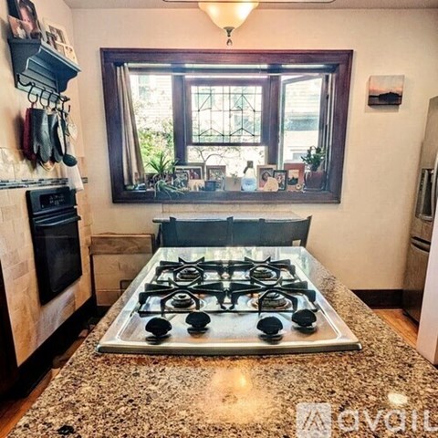 A kitchen with a granite countertop and a window.