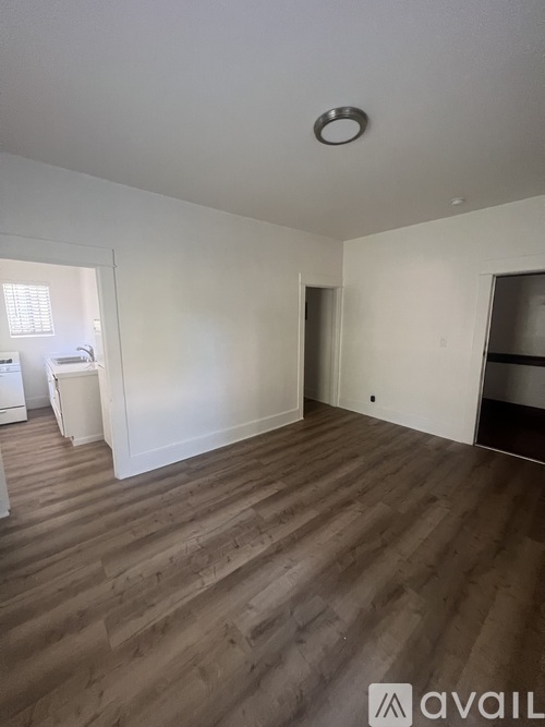 A room with wooden flooring and white walls.