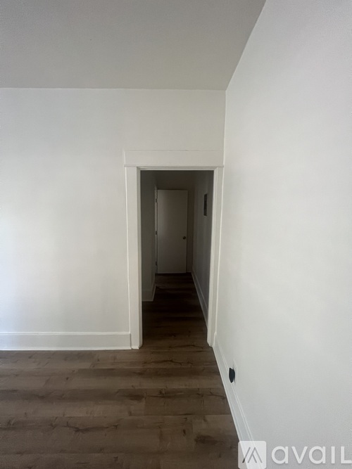 A hallway with a doorway leading to another room.