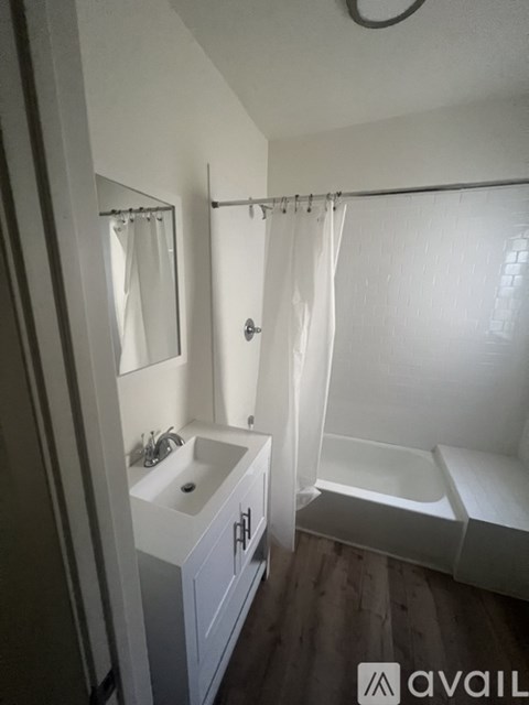 A bathroom with a white sink and a white bathtub.