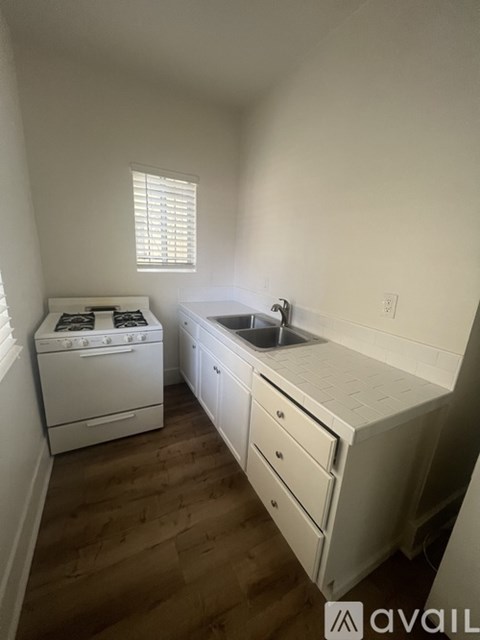 A small kitchen with a white oven and sink.