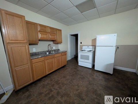 A kitchen with brown cabinets and a white refrigerator.