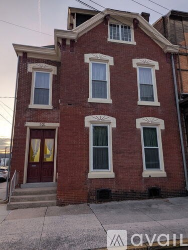 A red brick building with a brown door and windows.