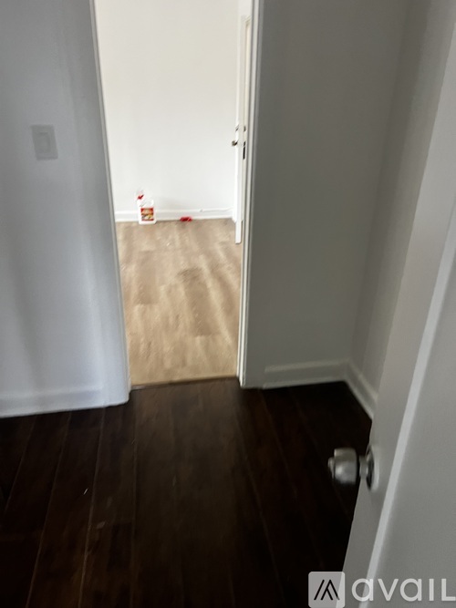 A hallway with a white door and a brown carpet.