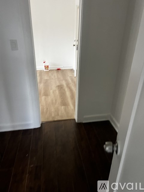 A hallway with a white door and a brown carpet.