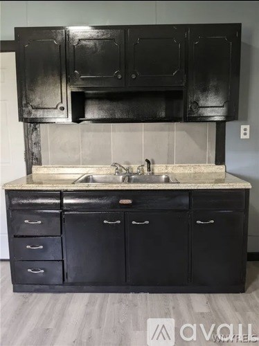 A kitchen with black cabinets and a marble countertop.