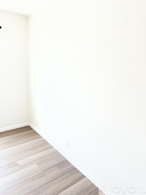 A room with a wooden floor and white walls.