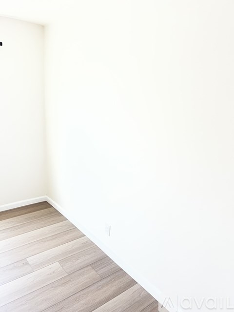 A room with a wooden floor and white walls.