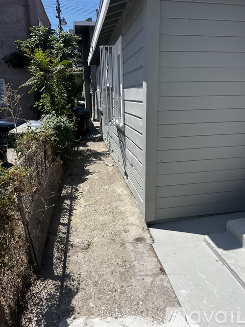 A narrow alley with a wall on one side and a building on the other.