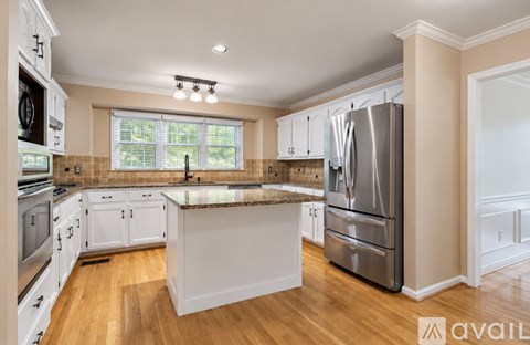 A kitchen with white cabinets and a granite countertop.