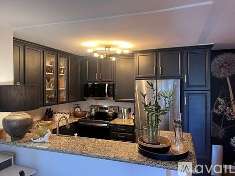 A kitchen with dark wood cabinets and granite countertops.