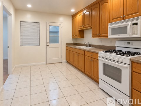 A kitchen with white appliances and wooden cabinets.