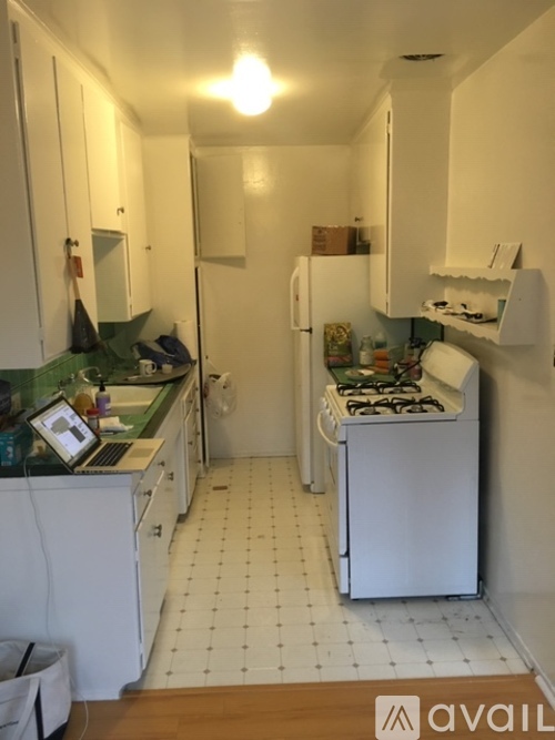 A kitchen with white cabinets and a green counter top.