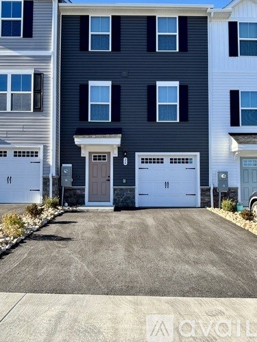 A two-story house with a garage door and a driveway.