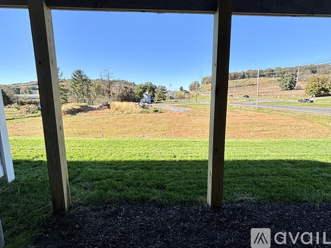 A view from a porch looking out to a grassy field.