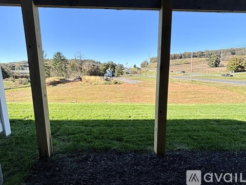 A view from a porch looking out to a grassy field.